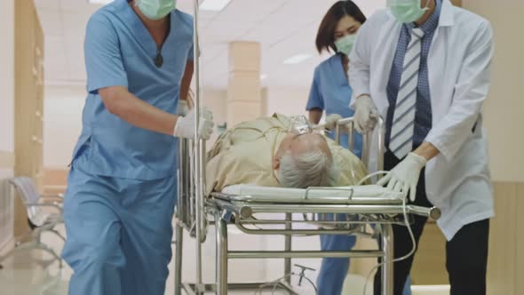 Group of doctor, nurse and surgeon moving seriously injured patient lying on a stretcher in hospital alt