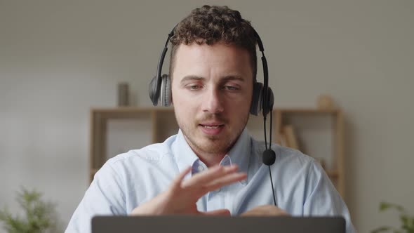 Attractive Young Man Counsellor Wear Headset Communicates to Client Remotely Via Video Call App on alt