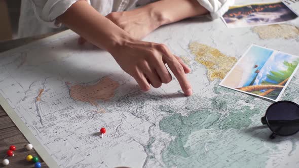 Tourist Vacation Planning With Help World Map With Tourist Accessories Around. Young Woman Pointing alt