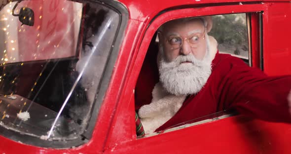 Portrait of Angry Aggressive Santa Claus Shouting Something From a Red Truck