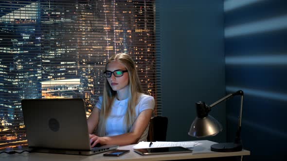 Beautiful Female Programmer Working on the Computer in Modern Office in the Evening alt