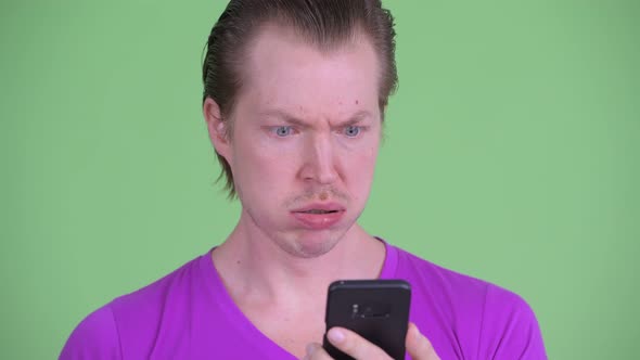Face of Stressed Young Man Using Phone and Looking Shocked alt