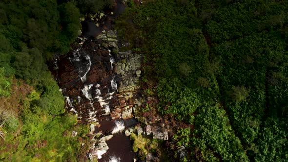 Aerial view Waterfall in Snowdonia National Park, Wales. Sunset following the footage. alt