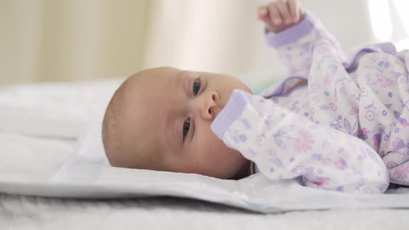 Mother Takes Off White Bodysuit From Baby