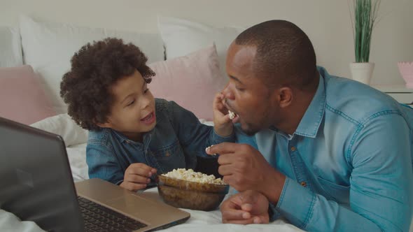 Joyful Father and Son Enjoying Leisure on Bed alt