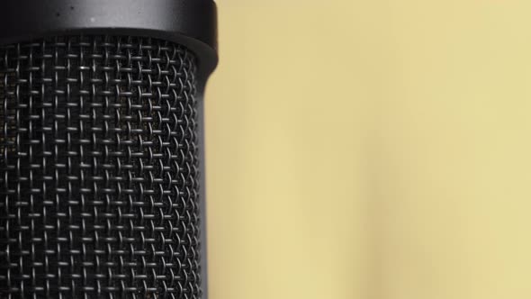 Studio Condenser Microphone Rotates on Yellow Background with Place for Text alt