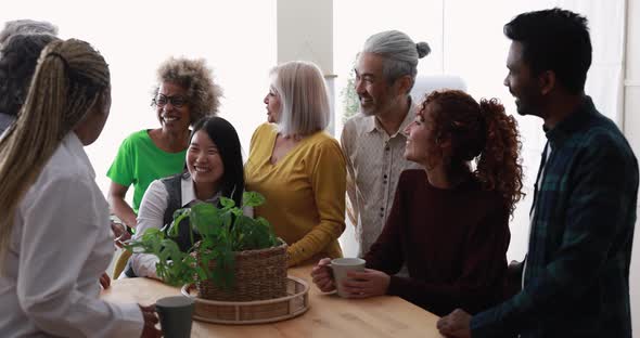 Multiracial happy friends having fun drinking coffee at home kitchen alt