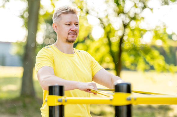 Man excercising with elastic rubber band outdoors