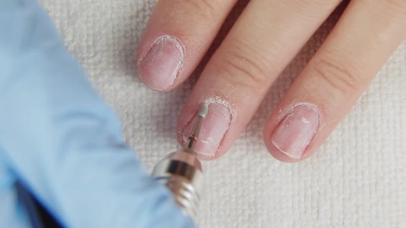 Young Woman Removes Gel Shellac Polish From Nails Using Manicure Machine