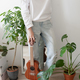 young woman at home playing ukulele standing near green plants - PhotoDune Item for Sale