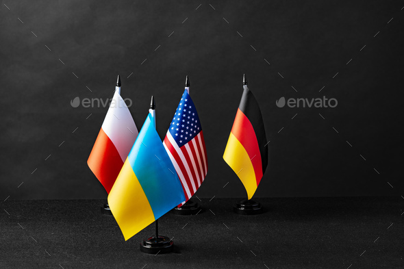 Four little flags of Germany, Ukraine, Poland and Usa on black background