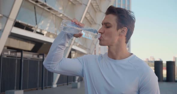 Handsome Young Man Athlete Drinking Clean Water After Cross Fit Training alt