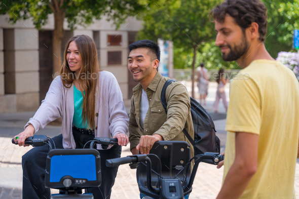 Group of multi-ethnic friends in the city meeting at meeting time next to rental bikes
