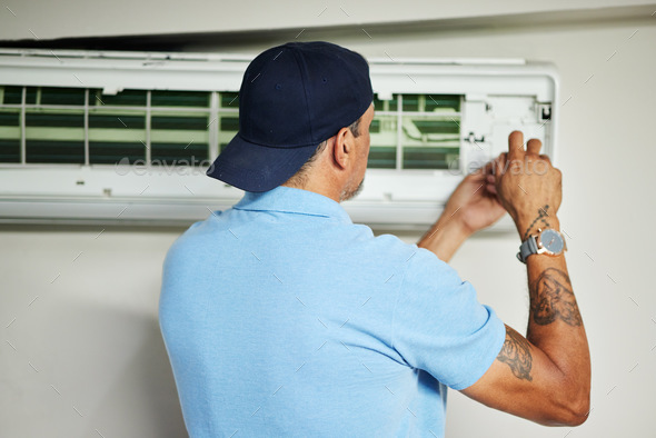 Man, electrician and ac repair for air conditioner maintenance from the back. Mechanic, technician