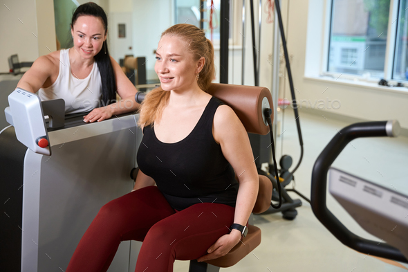 Fitness trainer studies the performance of the client on monitor