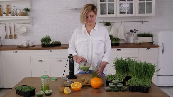 A Vegetarian Woman Pours a Fruit and Vegetable Smoothie Into a Jar with a Straw alt