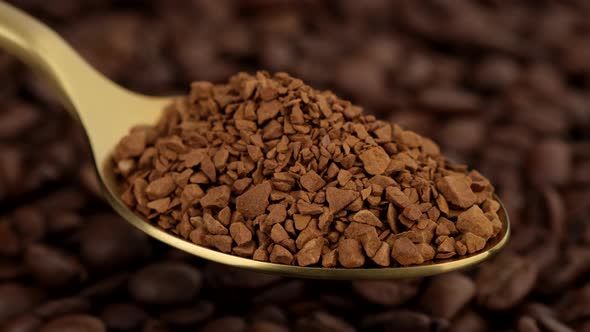 Coffee. instant coffee in golden spoon and coffee beans on background alt