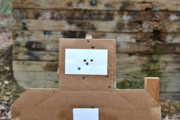 Bullet holes in paper targets at a gun range for target practice and firearms training