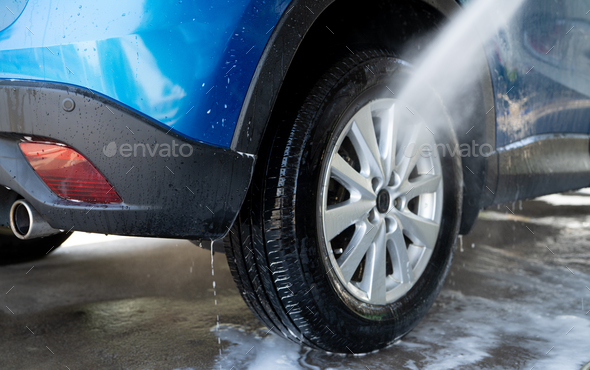 Car washing with high pressure water spray. Car cleaning. Auto care service concept. Vehicle clean