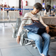 Tired Asian woman sleeping on airport departure waiting area chairs while waiting for flight - PhotoDune Item for Sale