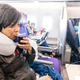 Asian woman drinking red wine whilst enjoying inflight entertainment during airplane journey - PhotoDune Item for Sale