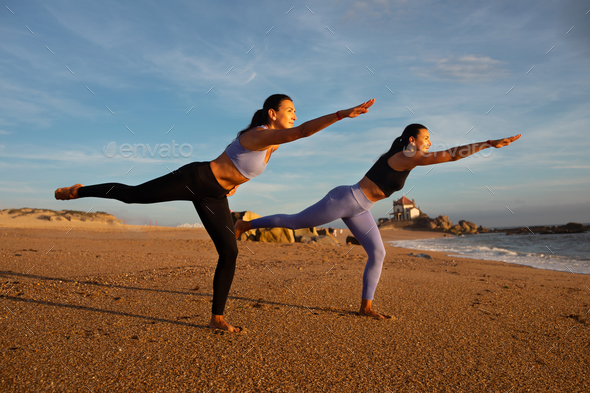 Happy slim millennial caucasian twins sisters women do exercises balance, practice  yoga, asana Stock Photo by Prostock-studio