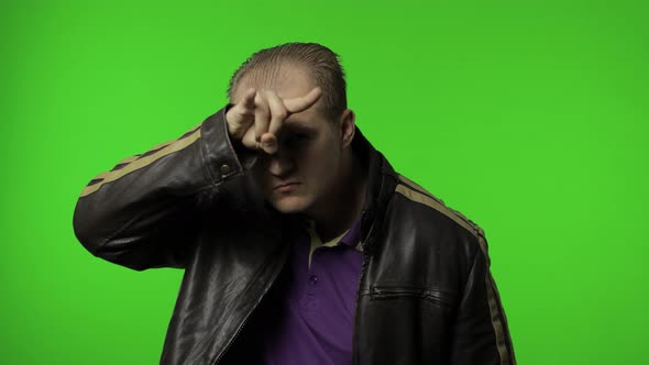 Angry Rocker Man in Brown Denim Jacket Demonstrating Bull Horns Gesture with Fingers on Head alt