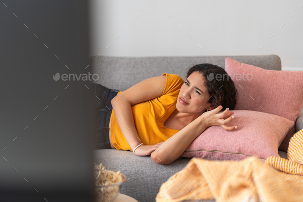 Annoyed young woman watching a series on TV