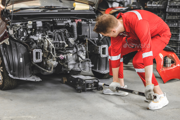 Auto shop staff worker overhaul gear engine broken car. Mechanic man using Hydraulic Floor Jack lift