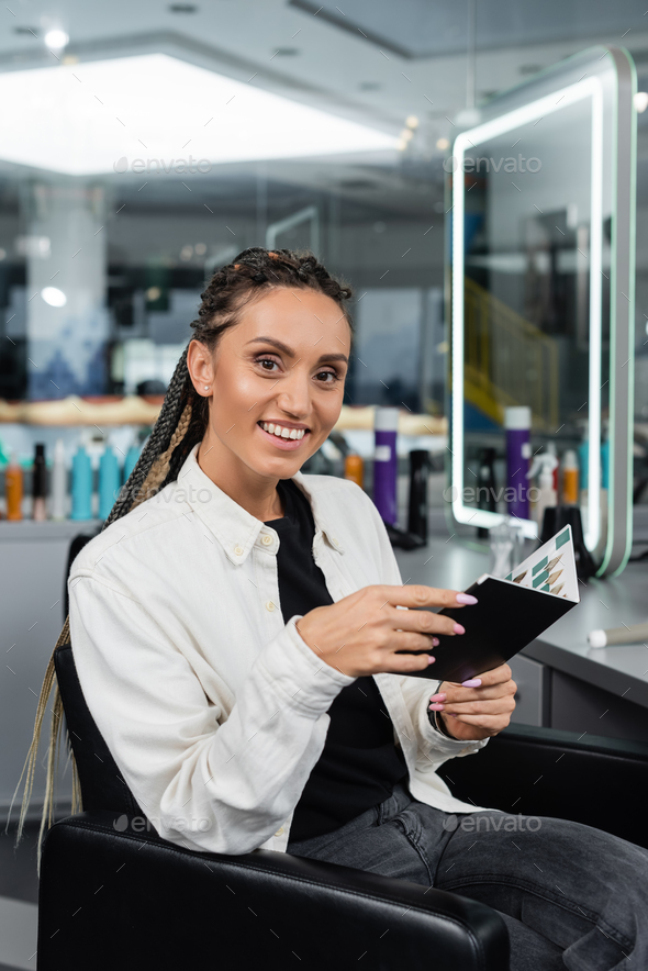 salon customer, woman with braids holding hair color palette in beauty salon