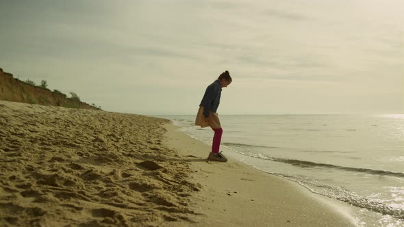 Small Girl Playing Outdoors on Sunset Beach alt