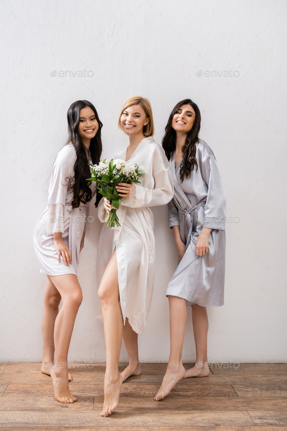 cheerful bride with white flowers, diverse bridesmaids, bridal bouquet, cultural diversity
