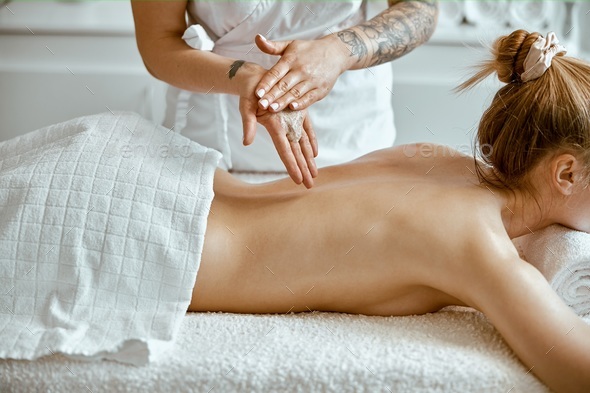 Caucasian woman getting a back massage in the spa salon Stock