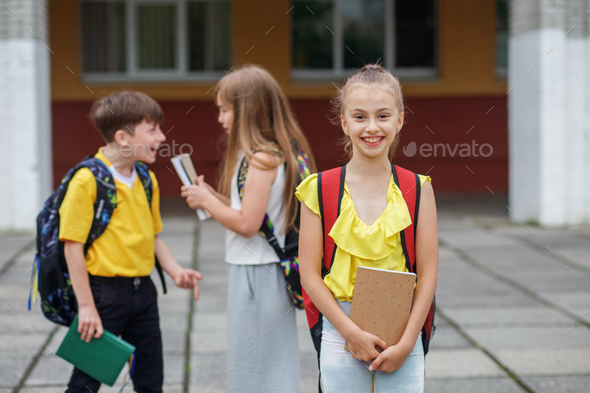 Smiling student with book and backpack outdoor. Back to school. Beginning of school lessons.