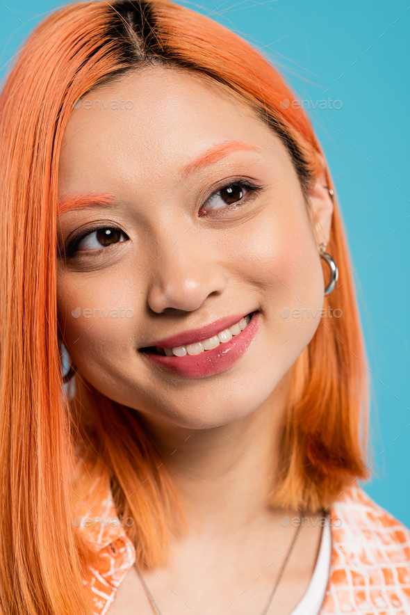 portrait, joyful asian woman with short and dyed hair, natural makeup and hoop earrings looking