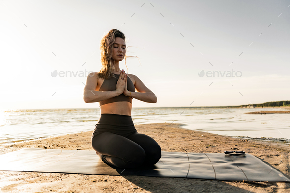 Young woman making yoga exercises and meditation. Fitness girl in