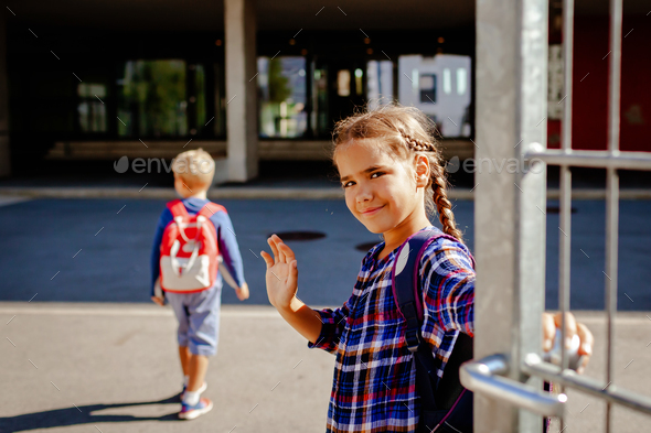 Back to school. Siblings with backpacks going to school from home at their first day after vacation
