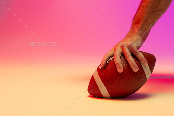 Football Player Holding Football With Both Hands Stock Photo