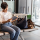 MIddle age Asian woman with luggage reading book while waiting for departure in airport terminal - PhotoDune Item for Sale