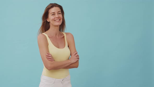Woman in Yellow Top and White Jeans Smiling to the Camera