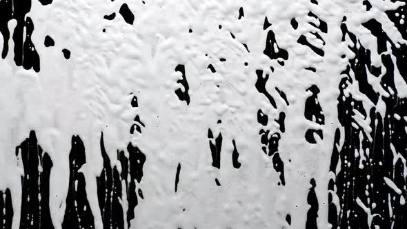 Detergent Disinfectant Is Sprayed Onto Glass in Slow Motion. Cleaning Glass From Dirt and Viruses alt