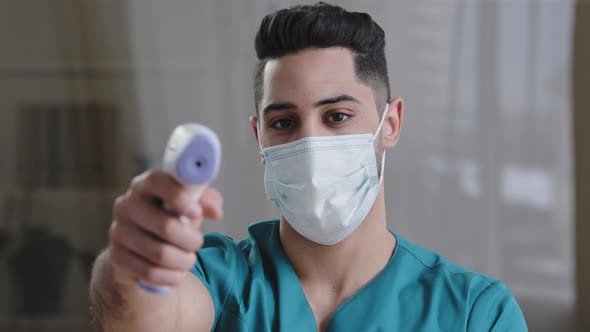 Arabian Male Medical Worker Doctor Surgeon Man in Protective Mask Taking Temperature with Noncontact alt