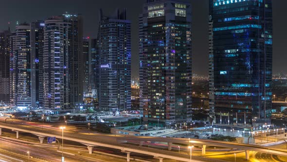Aerial View of Jumeirah Lakes Towers Skyscrapers Night Timelapse with Traffic on Sheikh Zayed Road alt