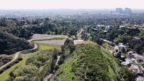 Aerial drone forward moving shot of roads and private mansions along hillside in Beverly Hills, Cali alt