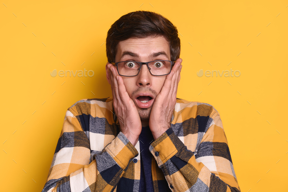 Closeup Of Amazed Handsome Guy In Glasses Isolated Over Yellow