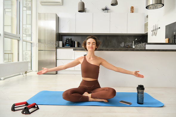 Mindfulness and meditation. Young relaxed fitness woman practice yoga at  home, sitting in meditation pose, lifting hands up to the air and doing  breathing exercises on rubber mat 35839164 Stock Photo at