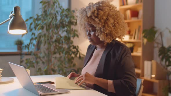 African American Businesswoman Working Late in Office alt