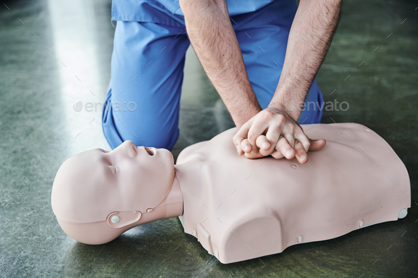 cropped view of professional healthcare worker doing chest compressions on CPR manikin