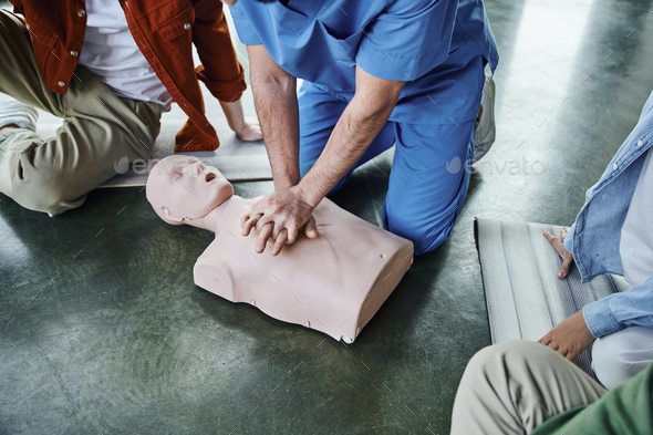 first aid hands-on learning, cropped view of healthcare worker doing chest compressions on CPR