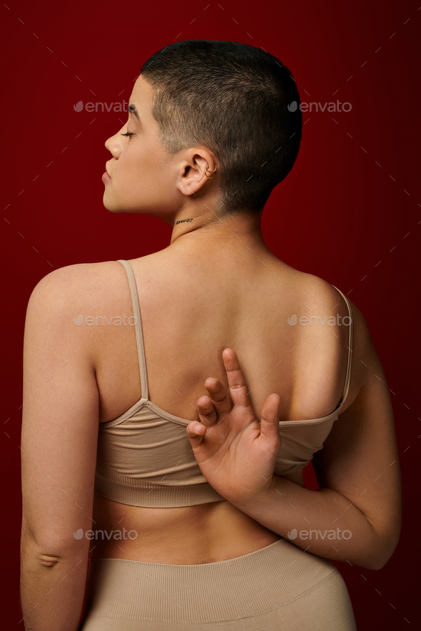 body positive, self-esteem, tattooed young woman with short hair and tattoo posing with hand behind